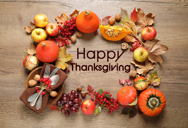 Плоская композиция с осенними овощами, фруктами и столовыми приборами на деревянном столе. Happy Thanksgiving Day
 - Фото, изображение