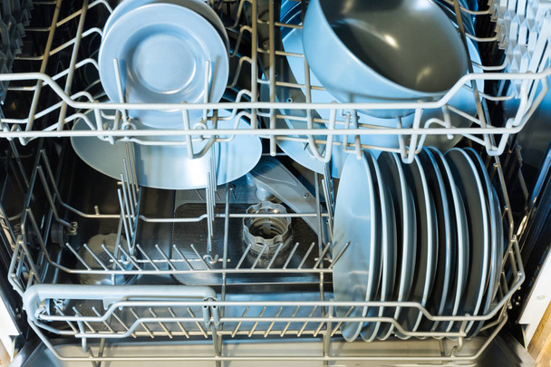 Открытая посудомоечная машина с чистой посудой. Чистые очки после мытья в посудомоечной машине
. - Фото, изображение