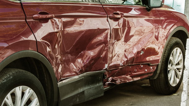 Het lichaam van de auto is beschadigd als gevolg van een ongeval. Hoge snelheid hoofd bij een auto-ongeluk. Dents op de carrosserie na een aanrijding op de snelweg - Foto, afbeelding