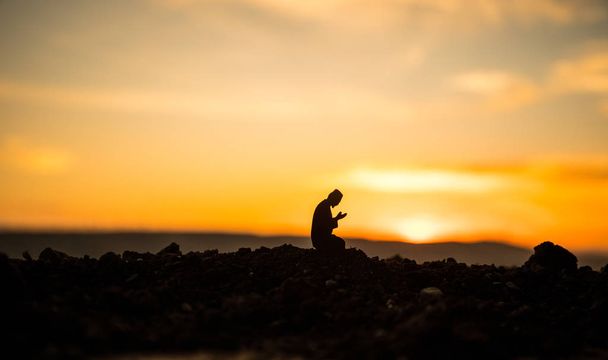 Uskonnon käsite Islam. Siluetti mies rukoilee taustalla moskeija auringonlaskun aikaan
 - Valokuva, kuva