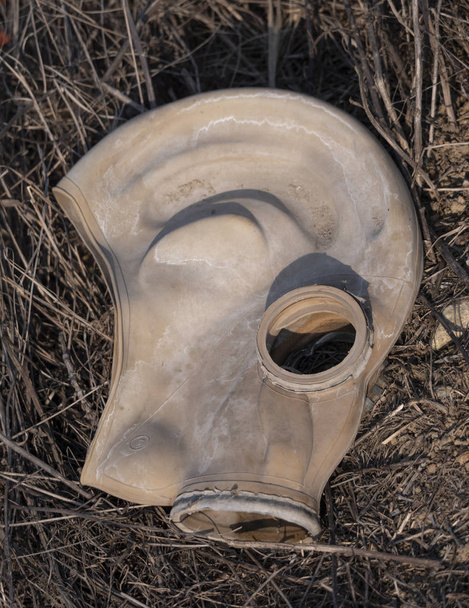 Yerdeki bir arazide eski bir gaz maskesi var. - Fotoğraf, Görsel
