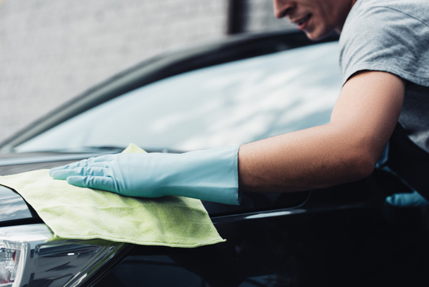 cropped view of car cleaner wiping car capote with rag - Foto, Imagem