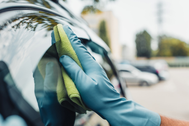 vista recortada del limpiador de coches limpiando la ventana lateral del coche con trapo
 - Foto, Imagen
