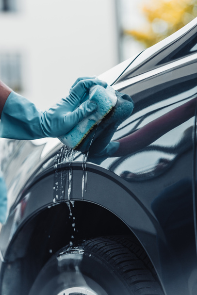 partial view of car cleaner washing car with sponge and detergent - Photo, Image