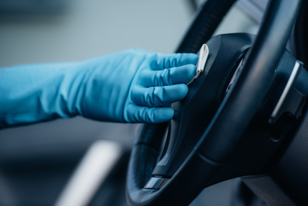 cropped view of car cleaner in rubber glove wiping steering wheel  - Photo, Image
