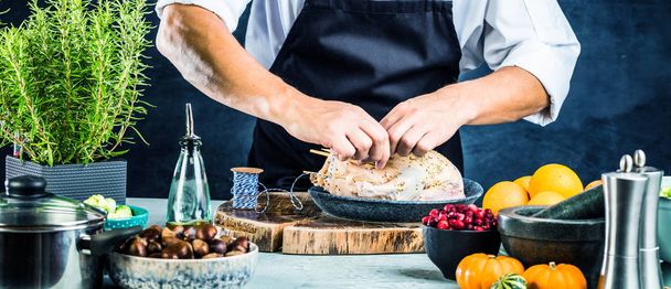 cropped shot of young male chef in apron preparing stuffed duck - Fotografie, Obrázek