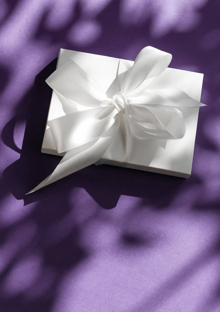 Роскошный праздник белый подарочная коробка с шелковой лентой и лук на фиолетовый
 - Фото, изображение