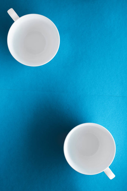 白い食器の食器セット、青いフラットレイバックグローの空のカップ - 写真・画像