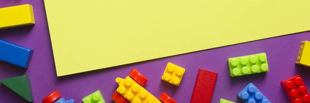 Colorful kids toys frame on wooden background. Top view. Flat lay. Copy space for text. - Fotó, kép