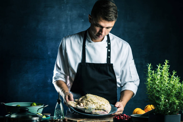young male chef in apron preparing stuffed duck - Foto, immagini