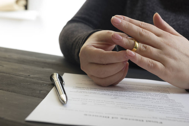 Ruce ženy, manžela, který podepisuje rozhodnutí o rozvodu, zrušení manželství, doklady o rozluce, žádosti o rozvod nebo předmanželskou dohodu vyhotovenou právníkem. Svatební prsten - Fotografie, Obrázek