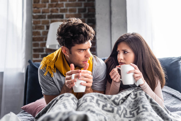 sick girlfriend and boyfriend holding cups with tea  - Foto, Imagem