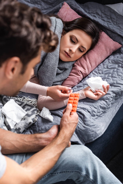 cropped view of boyfriend giving pills to sick girlfriend - Foto, Bild
