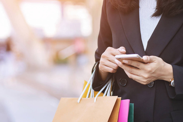 business woman holding hand many shopping bag in fashion boutique to shopping Convenient instant. Customers can use the mobile phone to shopping online Order purchase Sell and Payment transfer money. - Φωτογραφία, εικόνα