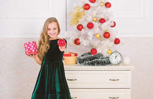 Traditional family holiday. Kid girl near christmas tree hold gift box. Child celebrate christmas at home. Favorite day of the year. Time to open christmas gifts. Opening christmas presents - Foto, Bild