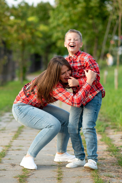 Mutter und Sohn, auf einem Weg im Park, frönen und lachen beim Gehen. - Foto, Bild