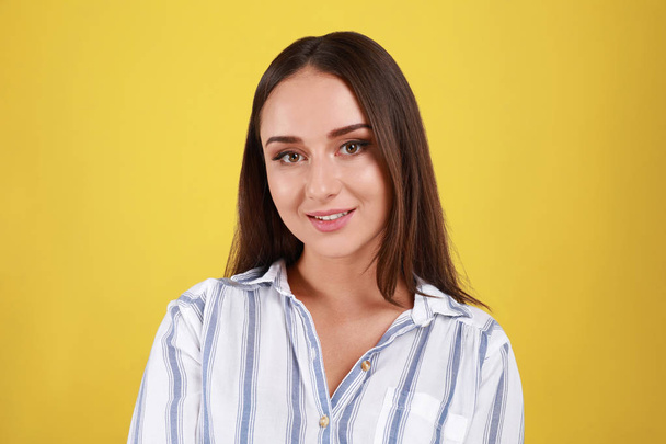 Beautiful young woman in casual outfit on yellow background - Фото, изображение