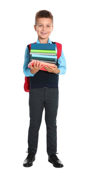 Happy boy in school uniform with stack of books on white background - Foto, immagini