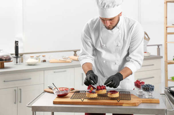 Male pastry chef preparing desserts at table in kitchen - Foto, Imagen