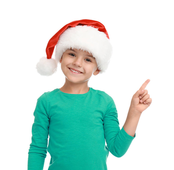 Cute little child wearing Santa hat on white background. Christmas holiday - Photo, Image