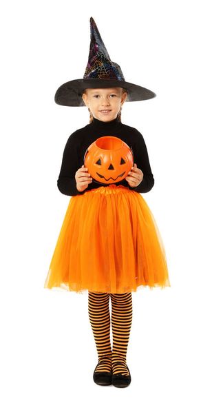 Cute little girl with pumpkin candy bucket wearing Halloween costume on white background - Foto, Imagem