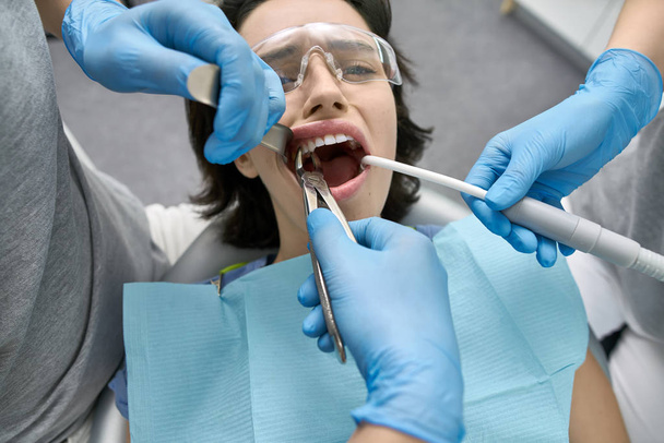 Pretty womans teeth treatment in dental clinic - Foto, imagen