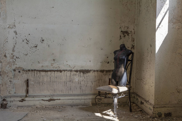 Ancienne chaise avec mannequin en plastique noir moule torse dans un bâtiment abandonné
 - Photo, image