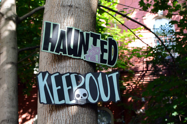 Στοιχειωμένο Κρατήστε έξω σημάδι στο Trunk Δέντρο μπροστά από το τρομακτικό σπίτι - Φωτογραφία, εικόνα