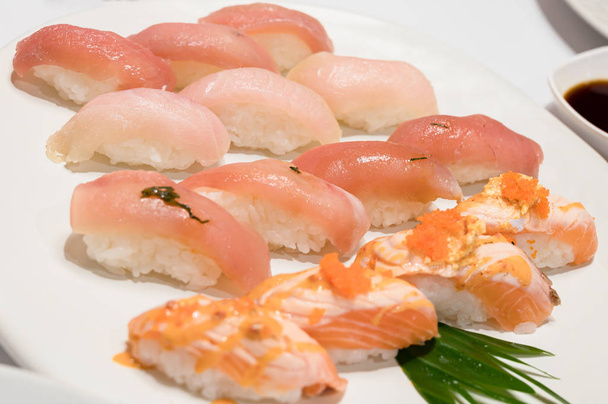 Sushi mit Lachs, Hamachi und Akami (Roter Thun) auf weißem Teller. - Foto, Bild