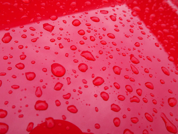 Kiválasztott összpontosított esőcsepp tetején a piros fém.  - Fotó, kép