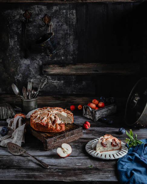 delicious homemade pie with apples and utensil on old dark table  - Photo, image