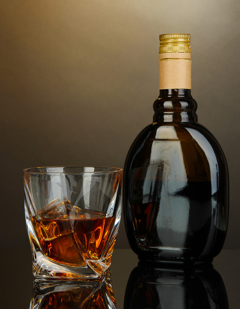 Glass of liquor with bottle, on dark background - Foto, Imagem