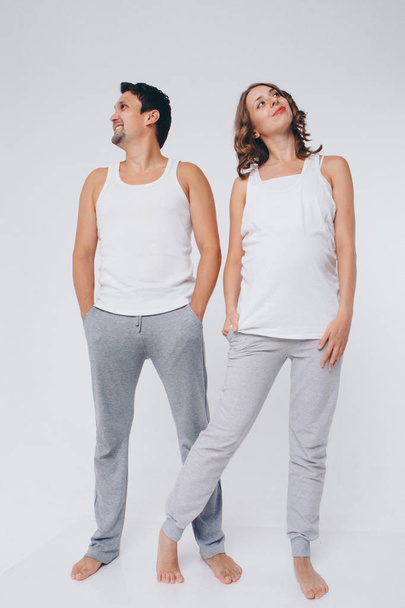 two people in identical poses. A man and a pregnant woman quite look in different hand. The concept of healthy digestion, lifestyle - Φωτογραφία, εικόνα