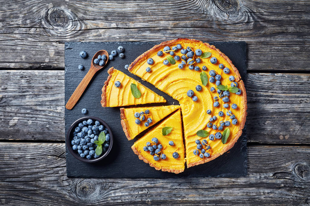 sweet pumpkin pie decorated with fresh blueberries - Фото, изображение