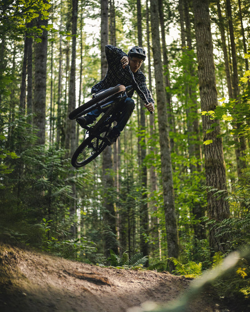 Élégant saut à vélo de montagne Prélèvement d'air en forêt - Photo, image