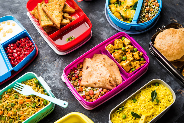 インドの子供のためのランチボックス/ティフィンのグループ、あなたの学校に行く子供のための健康食品の多様性または複数のオプションまたは組み合わせを示す - 写真・画像