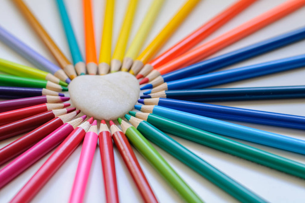 forma di cuore di matite colorate su sfondo bianco
 - Foto, immagini