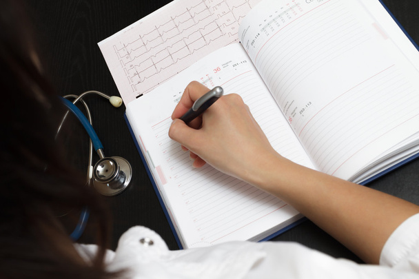 Doctor writing medical records - Photo, Image