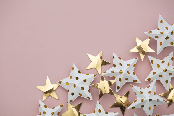White and gold star decorations on a pastel pink. Seasonal festi - Фото, зображення