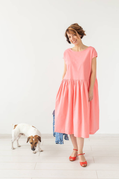pets owner concept - young woman in pink dress with jack russell terrier dog over the white background - Photo, Image