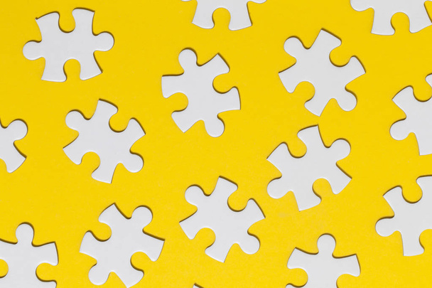 White jigsaw puzzle pieces on a yellow background. Business solu - Fotoğraf, Görsel