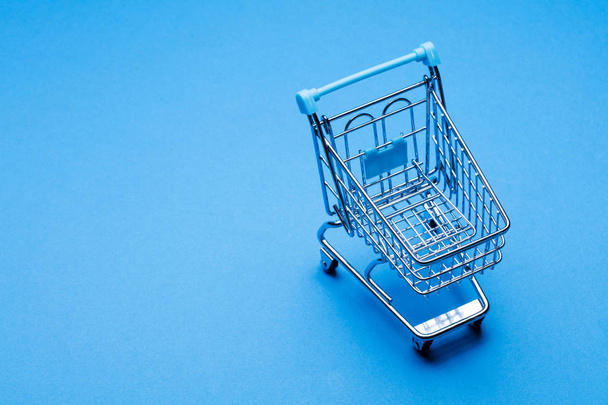 Shopping cart on a blue background - Zdjęcie, obraz