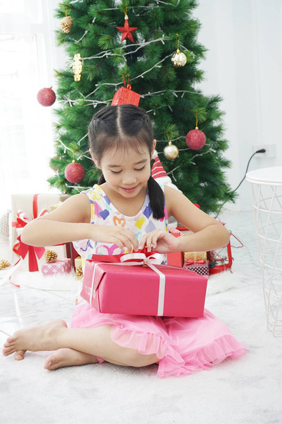 La chica está entusiasmada con los regalos en la Navidad
 - Foto, imagen