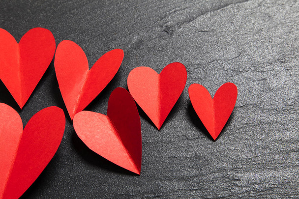 Red handmade paper hearts on a slate background - Foto, Bild