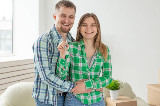 Young married couple with boxes and holding flat keys. - Zdjęcie, obraz
