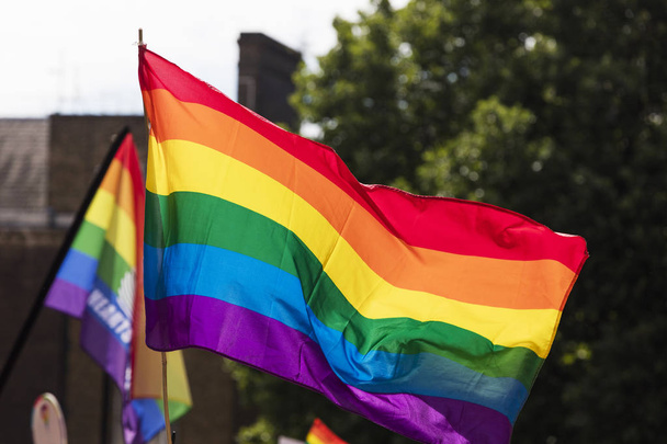 Gay rainbow flag being waved at an LGBT gay pride march in Londo - Foto, imagen
