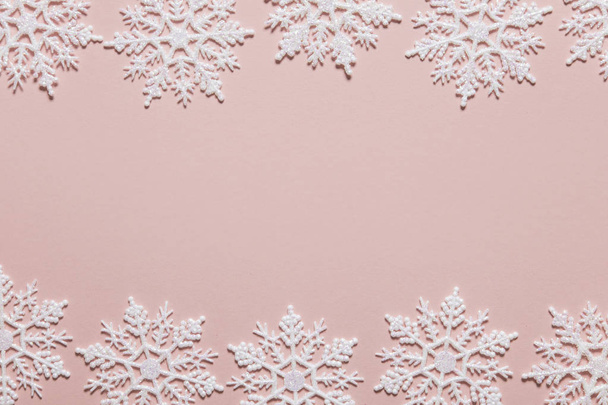 White glitter snowflake composition on a pastel pink background - Foto, Imagen