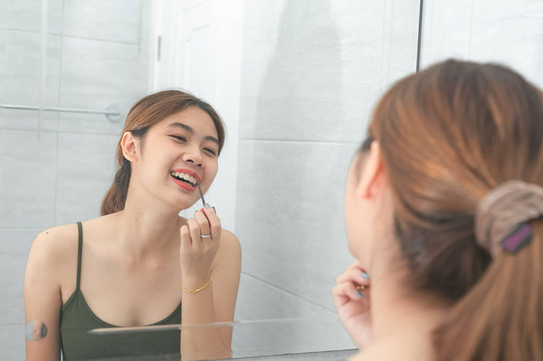 Asijské ženy s make-upem z červené rtěnky se zrcadlem v lázni - Fotografie, Obrázek