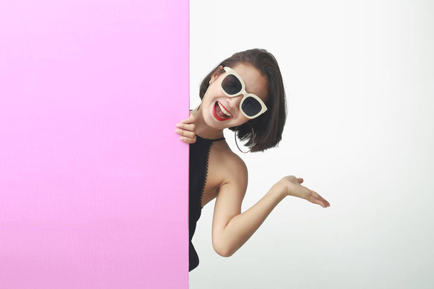 幸せな笑顔若いビジネス女性を示す空白のピンクの看板. - 写真・画像