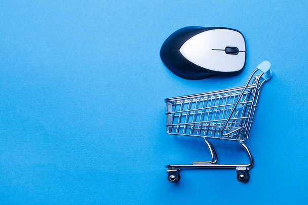 Shopping cart on a blue background with computer mouse - Zdjęcie, obraz